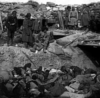 Russian soldiers stand over trench of dead Japanese
